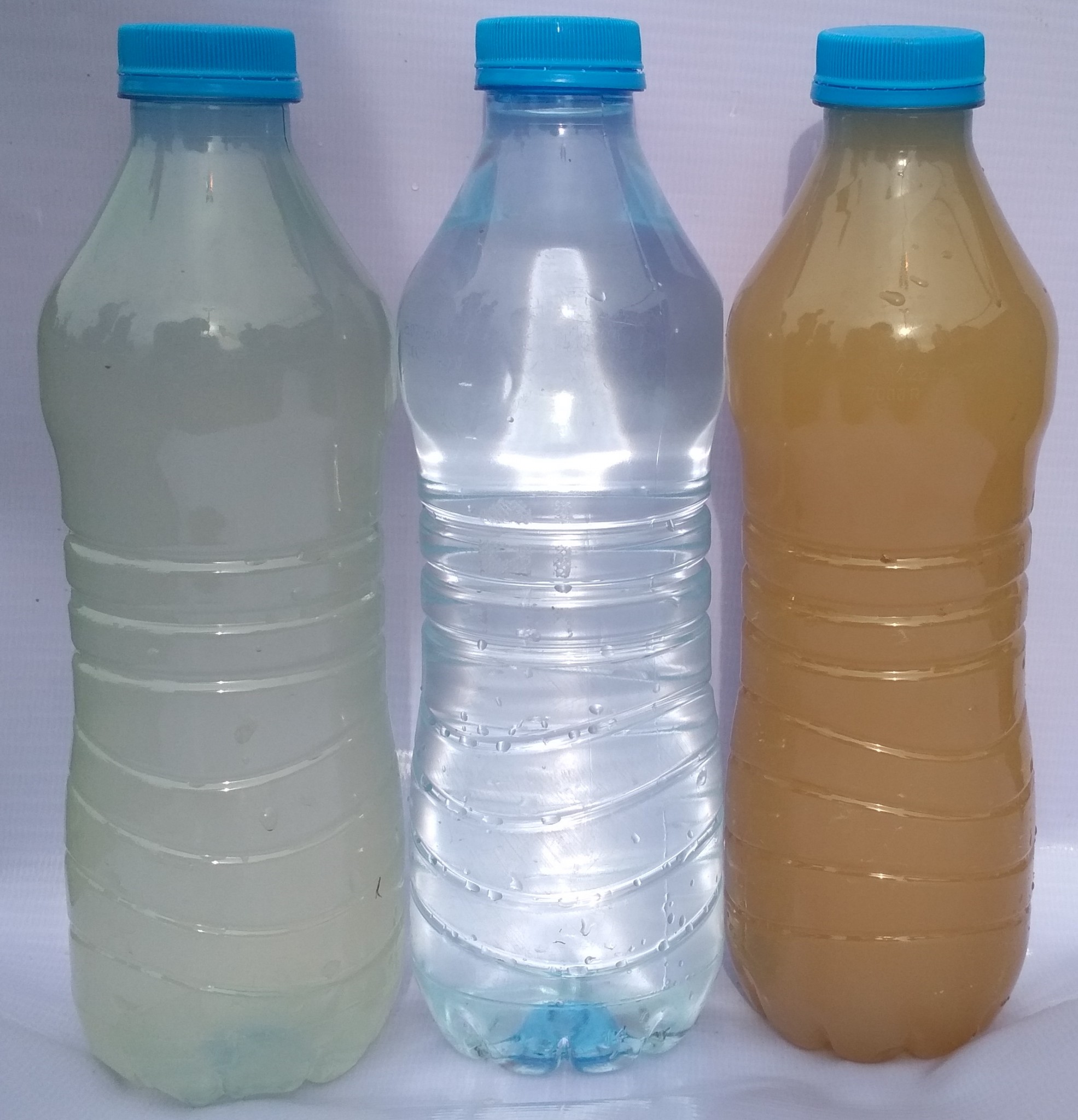Bottles with dirty surface water and clean and clear filtered drinking water