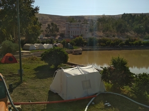 Turbid water pond in an earthquake disaster zone with emergency tent