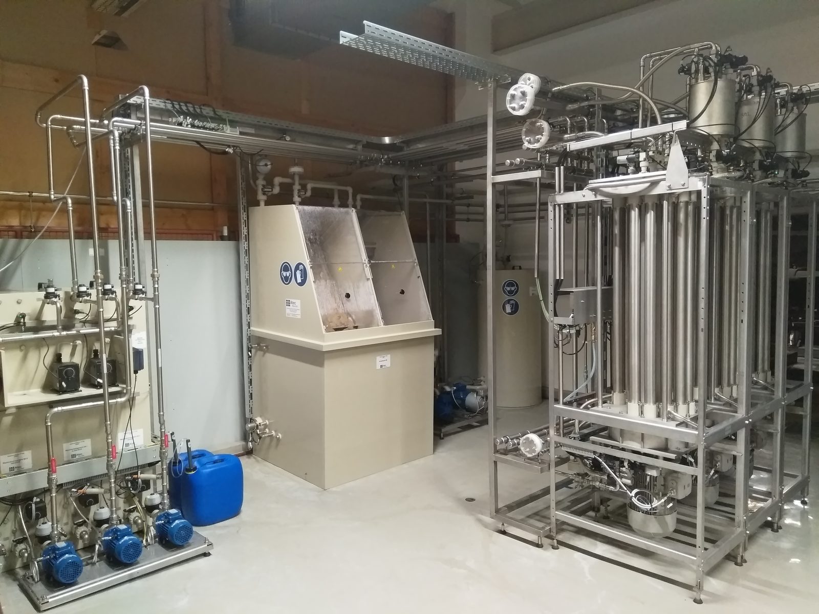 Cross-Flow-Filtrationsanlage von Atec mit senkrecht angeordneten Membrangehäusen, links die Dosierstation mit Pumpen.